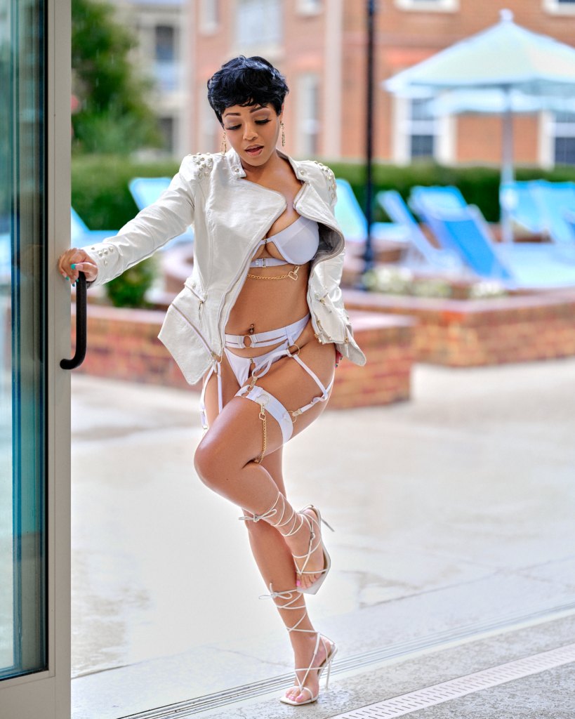 Fashion portrait in a white jacket in a poolside doorway, photographed by Daring Leaderman