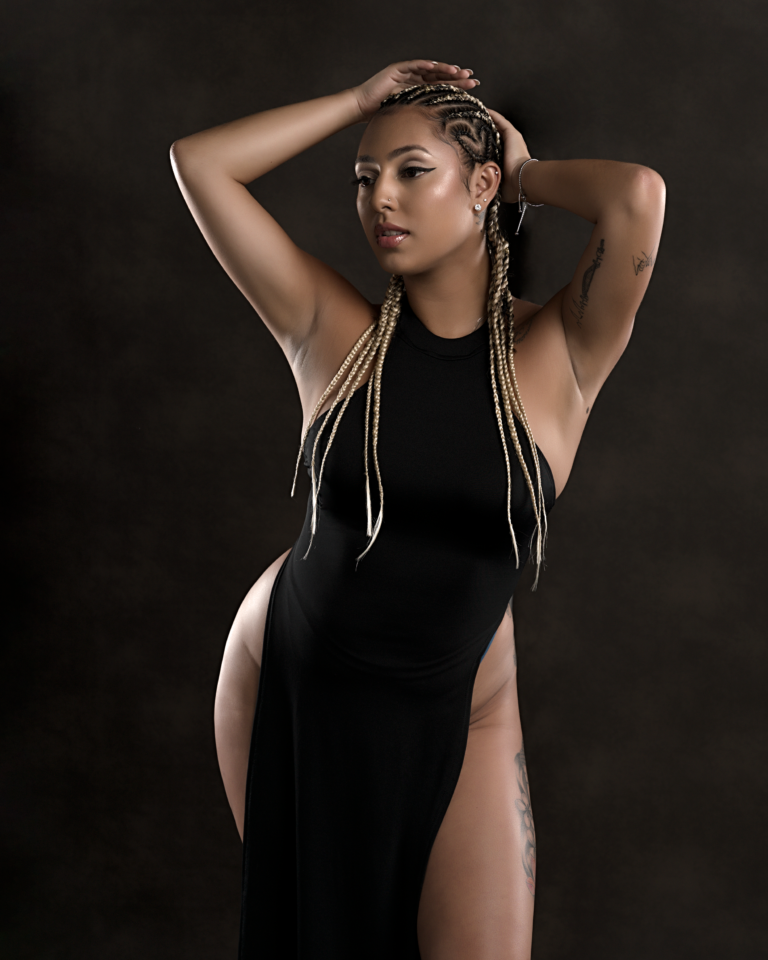 Fashion portrait in a black gown against a dark studio background